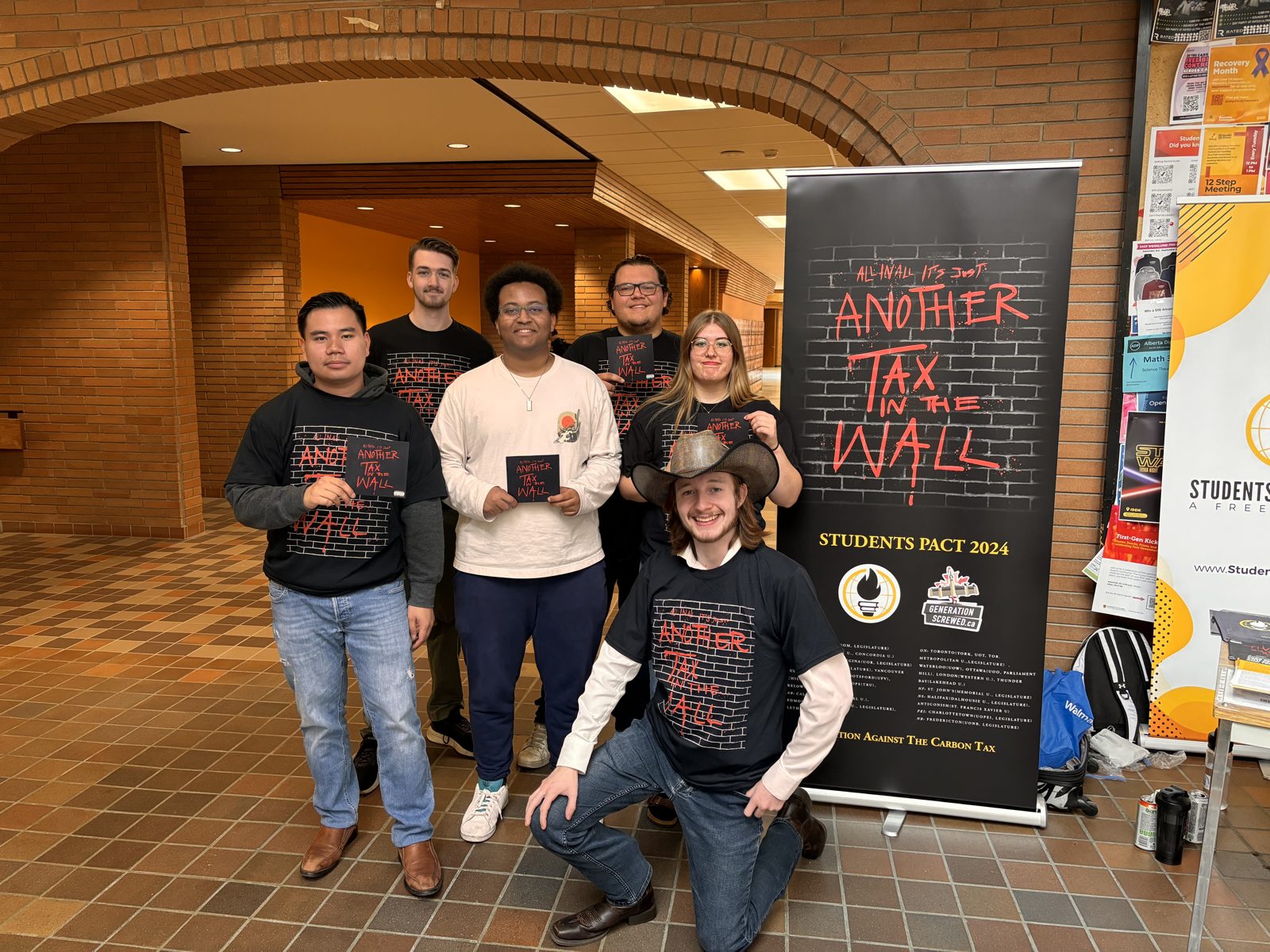 Generation Screwed members in GS shirts in front of the "Another Tax Wall" banner